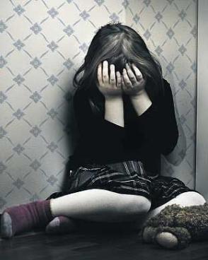 child huddled in corner